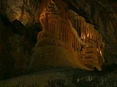 One huge, deep gold stalagmite that looks to be as big as a city building, although fatter. Deep clefts on its sides show where free stalactites originally hung. One could imagine a many-tiered Greek temple looking like this.