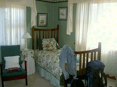 a typical guestroom, with bright furnishings and lacy curtains